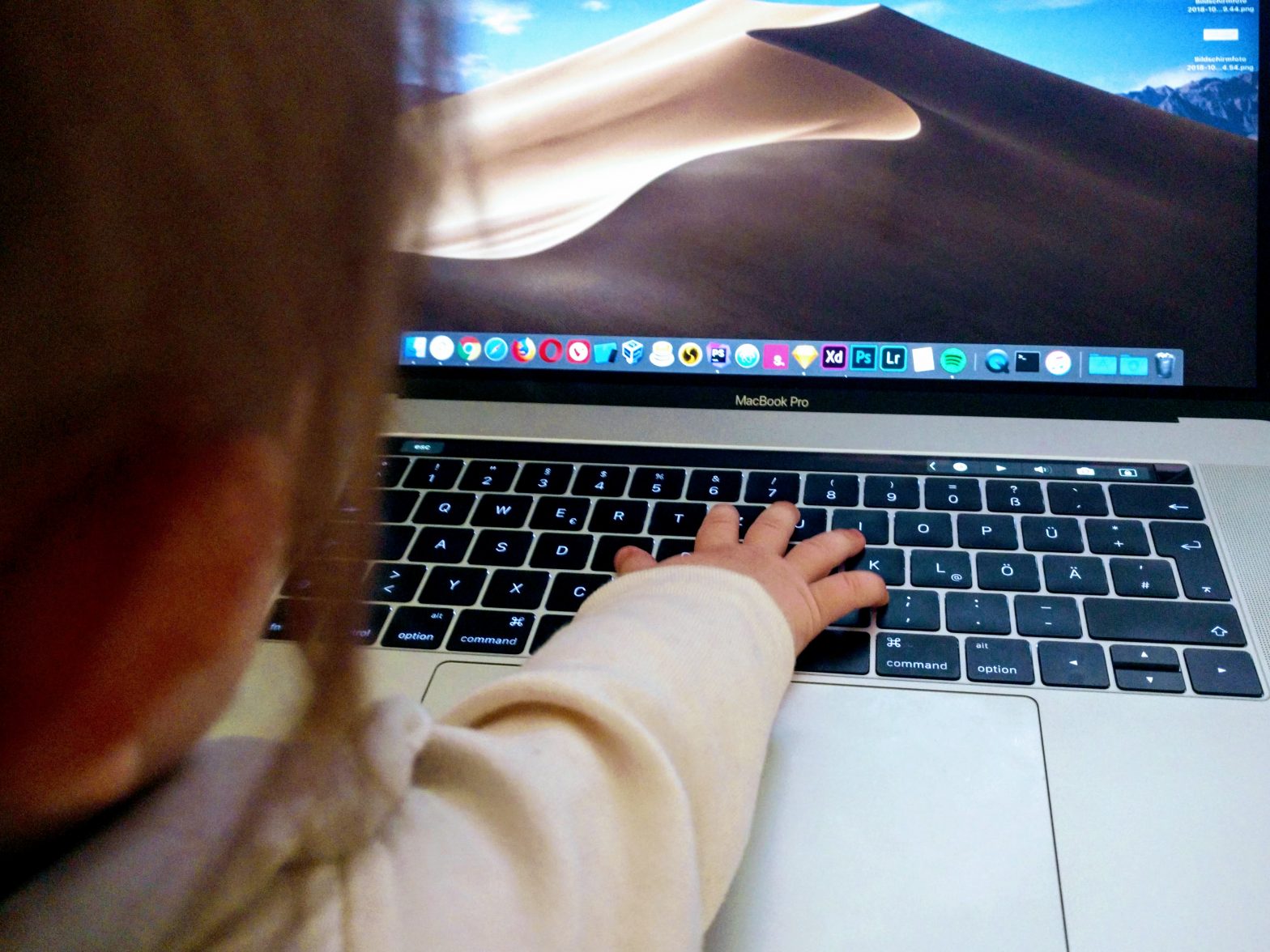 Hand eines Babys auf Laptop-Tastatur